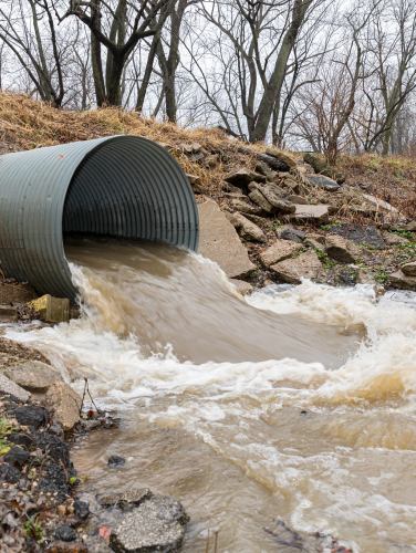 image of storm drain with water rushing out